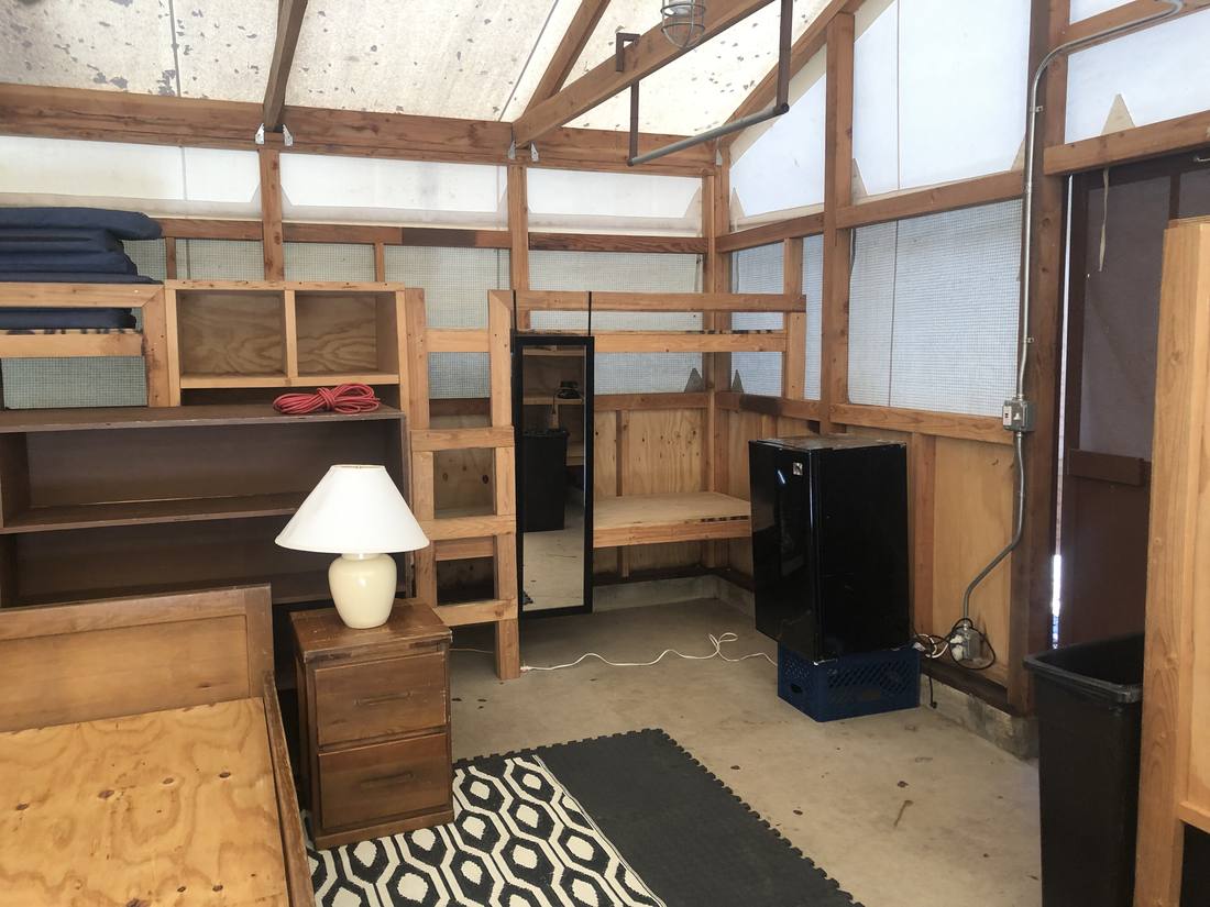 Inside a tent cabin — shelving, mini fridge, and storage